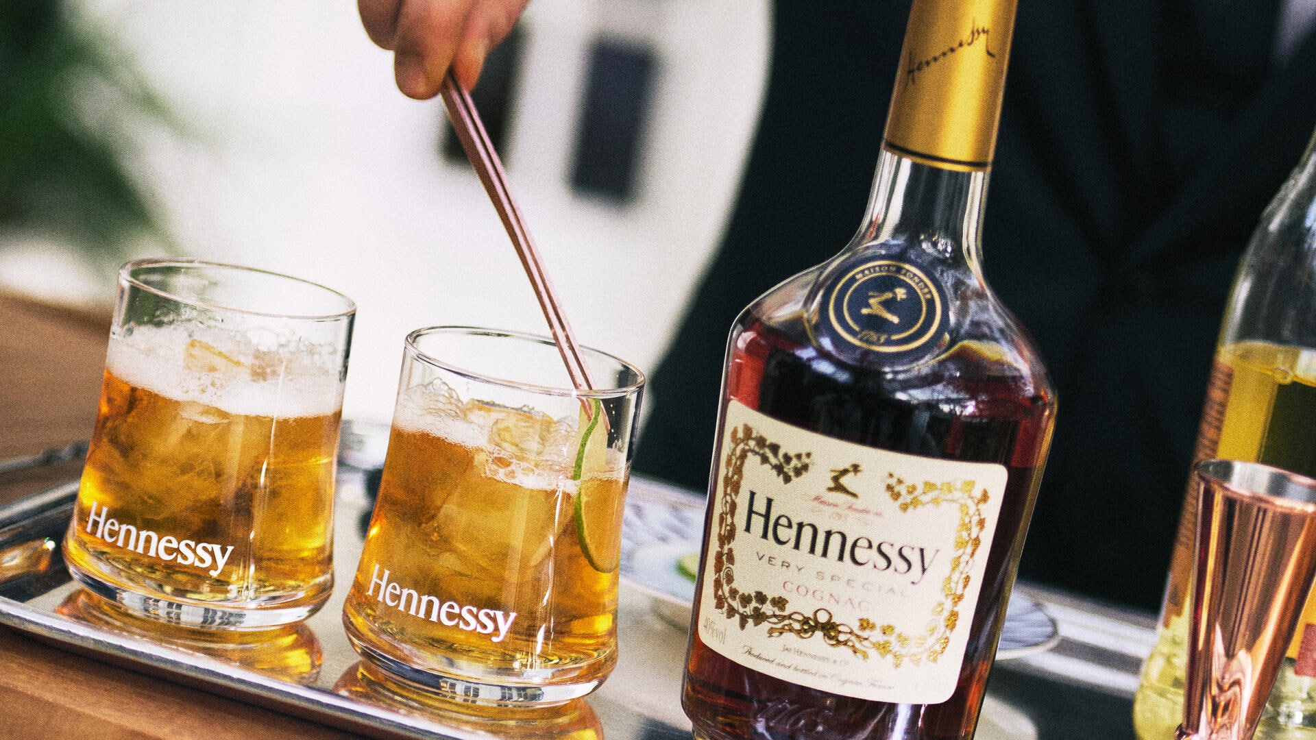 Bartender réalisant 2 cocktails Hennessy, à côté d'une bouteille de Hennessy V.S
