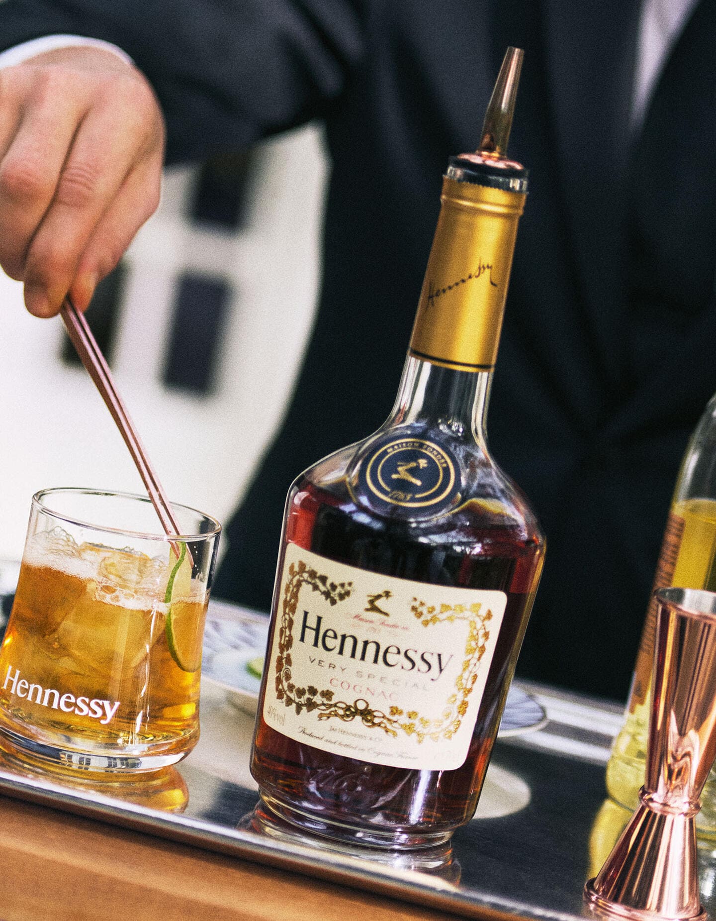 Bartender réalisant 2 cocktails Hennessy, à côté d'une bouteille de Hennessy V.S