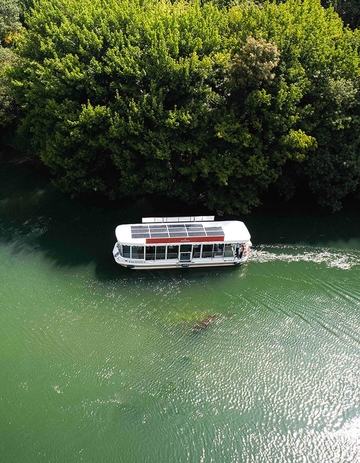 Bateau à énergie solaire Hennessy navigant sur les eaux émeraude de la Charente, à Cognac, en pleine nature