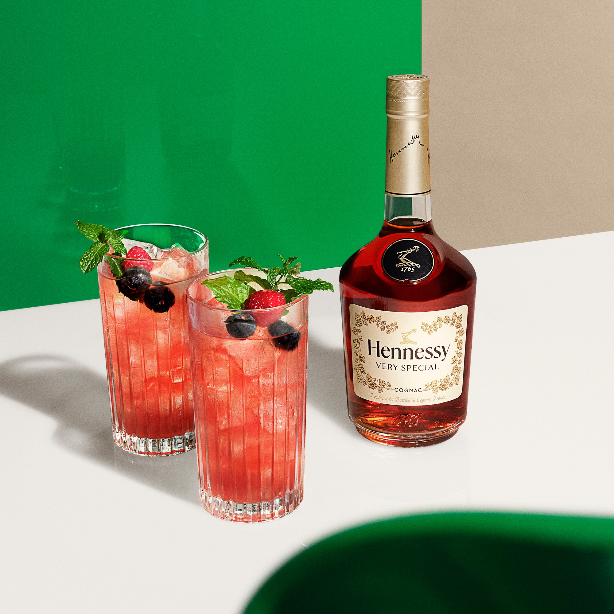 2 verres de cocktail Hennessy Berry, à côté d'une bouteille de Hennessy V.S