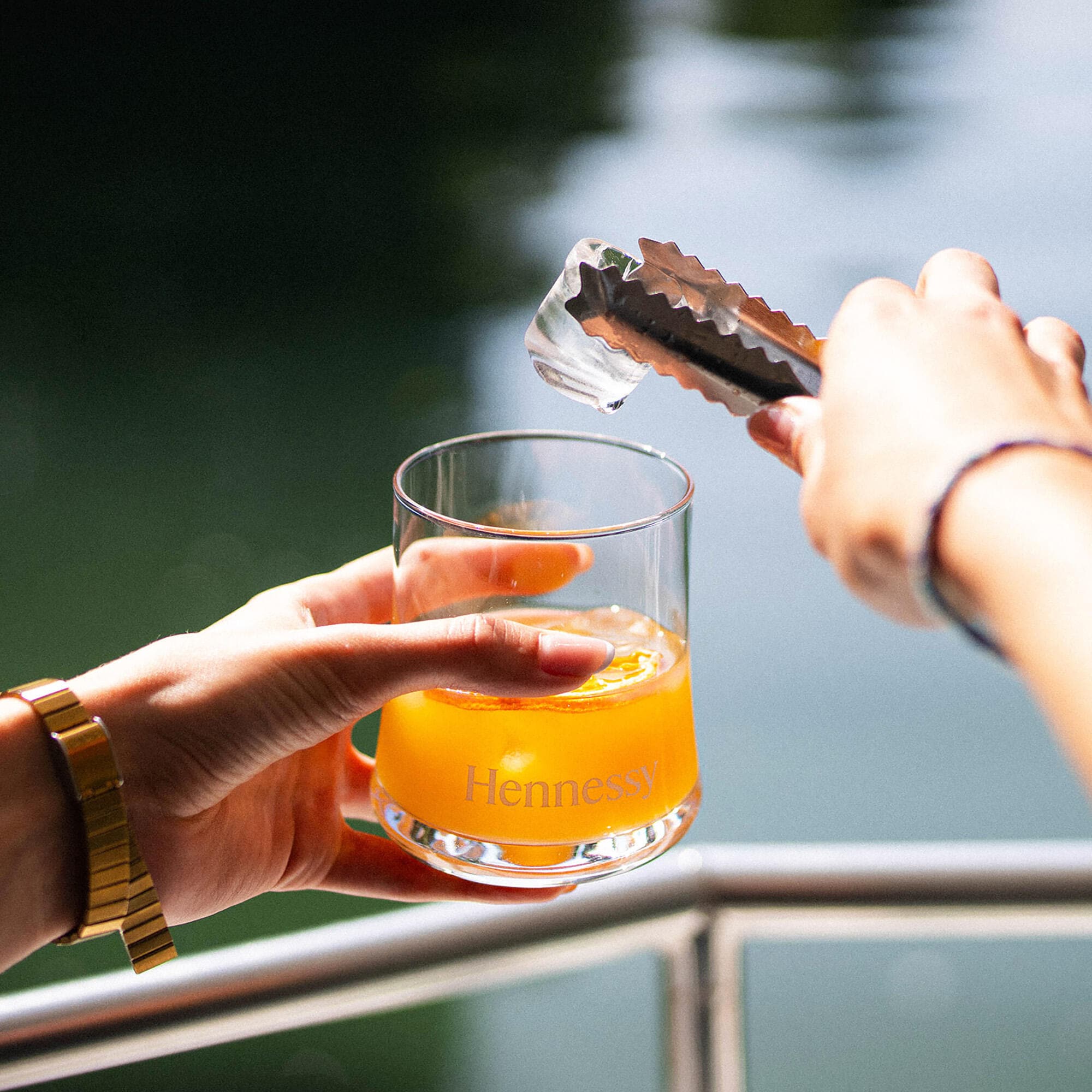 Guide Hennessy ajoutant un glaçon dans un cocktail au cognac Hennessy, à bord du bateau